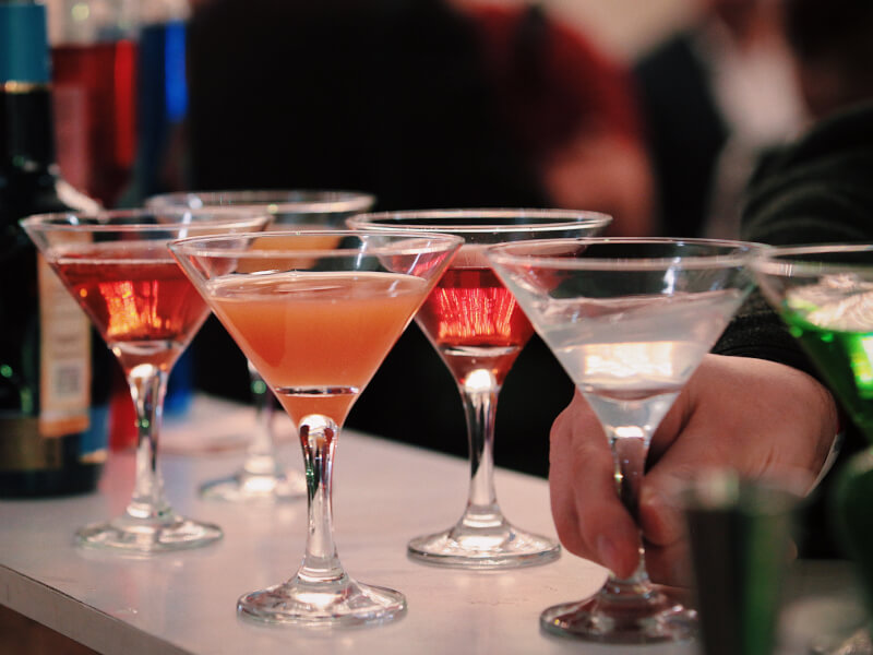 a row of cocktails in martini glasses